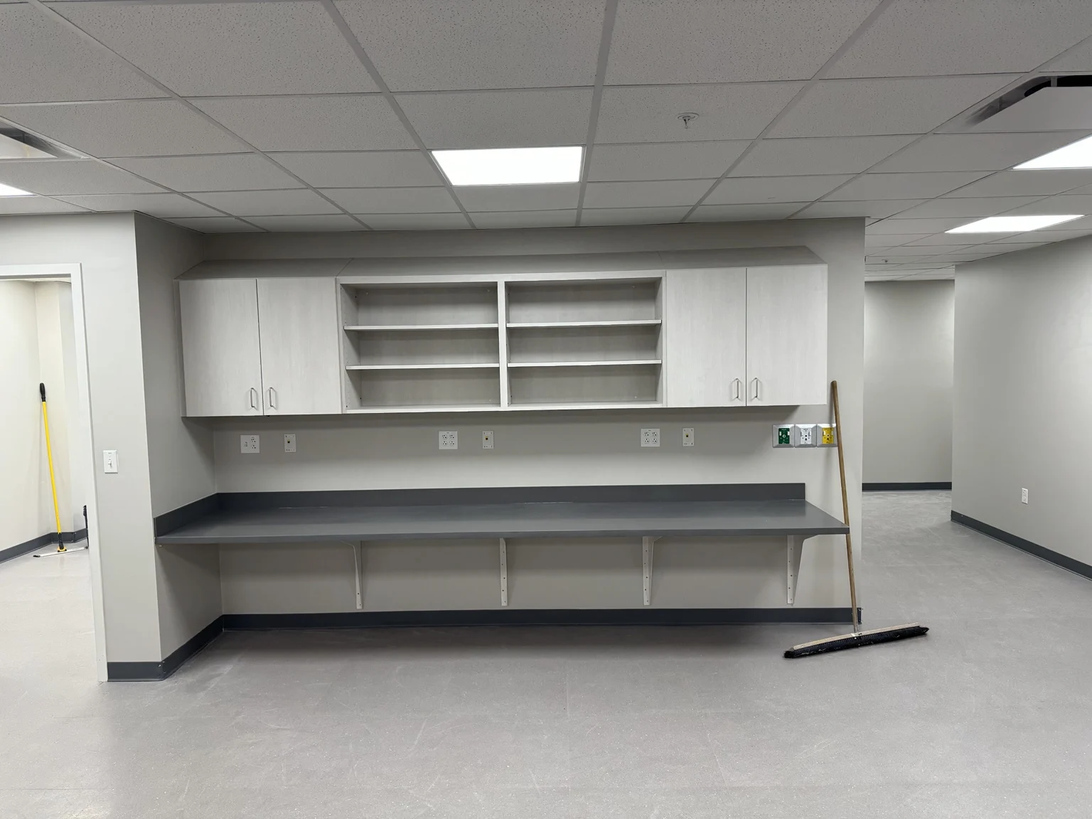 Commercial interior with wall cabinets, shelving, and a long work counter