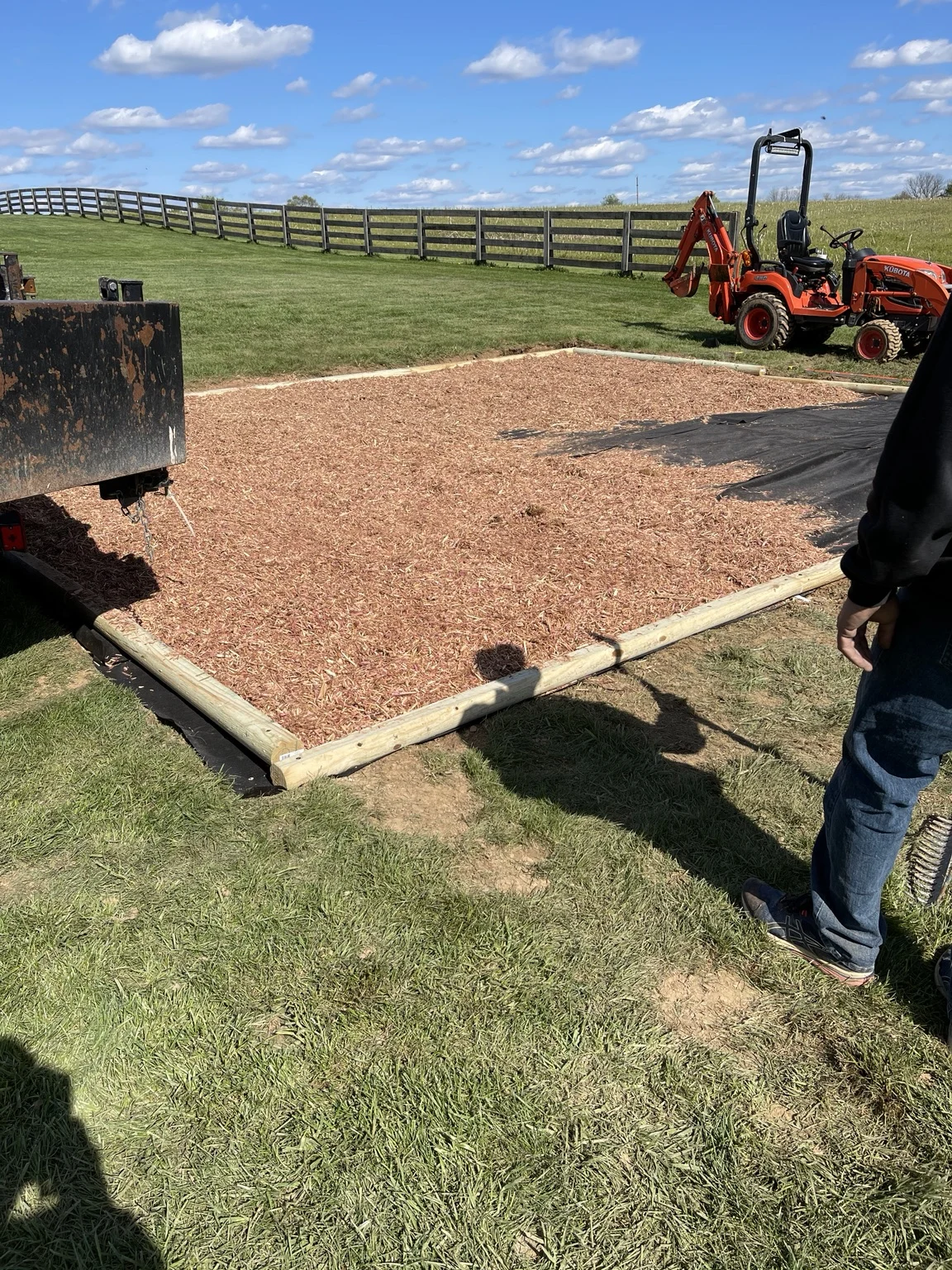 Timber-edged landscape bed with mulch during installation