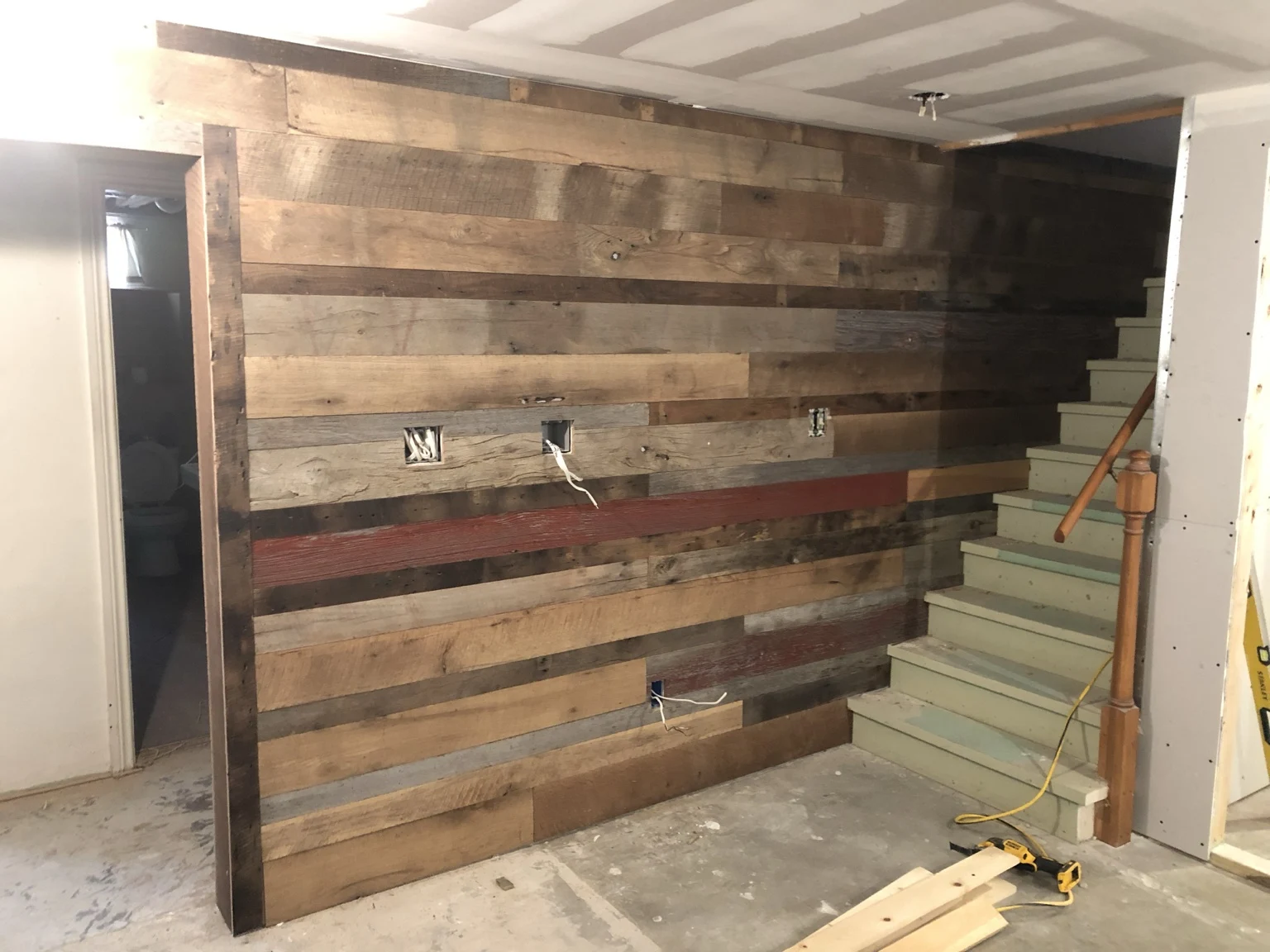 Horizontal wood accent wall beside a staircase during renovation